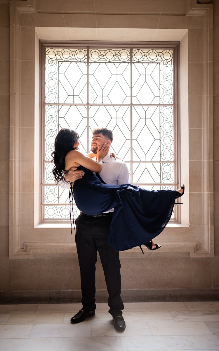 Man In A Suit Carrying A Woman In A Dress