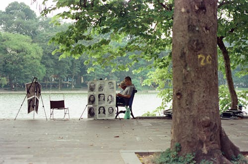Men Sitting in a Park and Sketching Portraits 