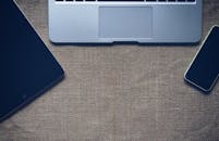 将笔记本电脑、平板电脑和智能手机平放在粗麻布表面，以促进技术与连接