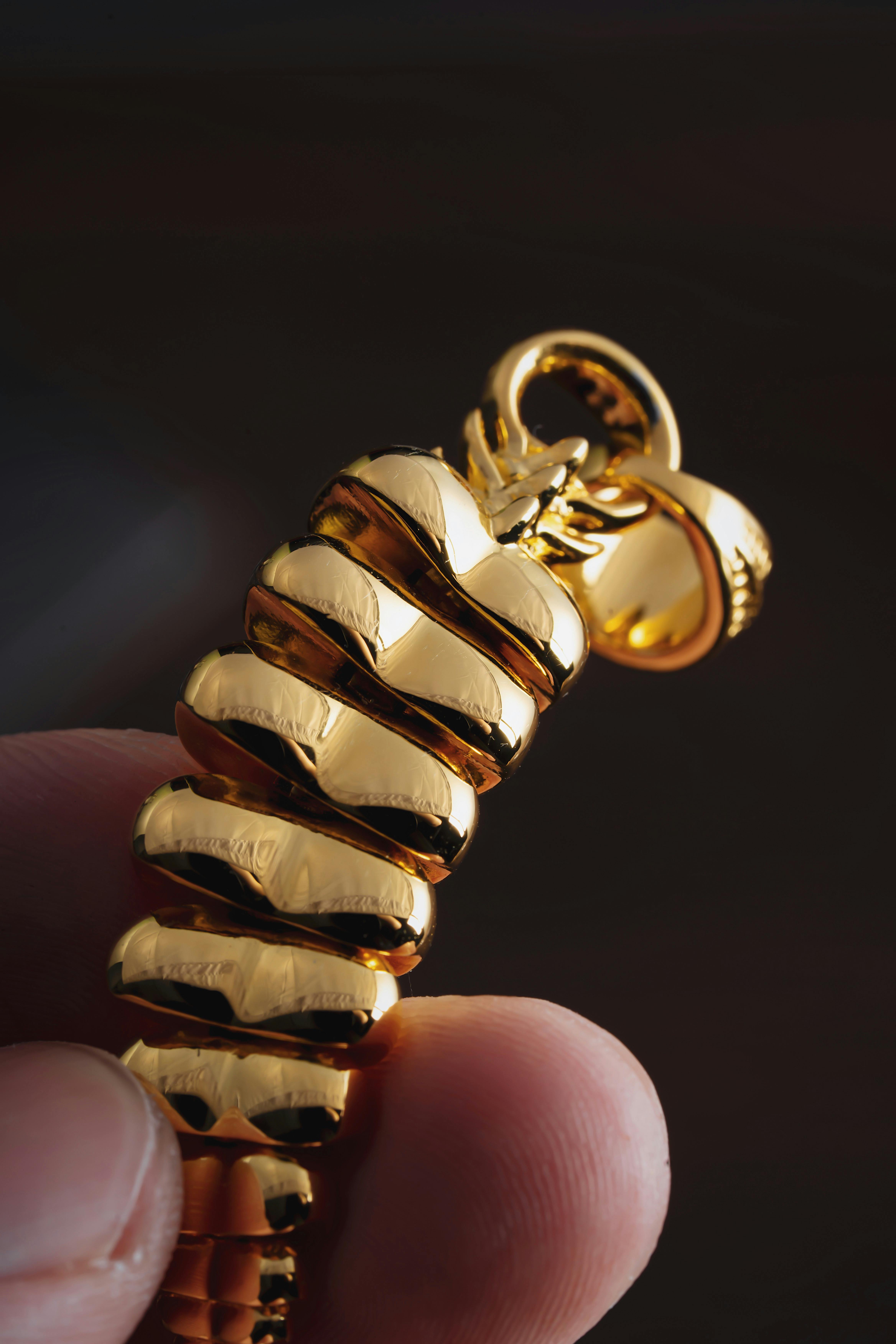 free photo of golden rattlesnake tail pendant in hand