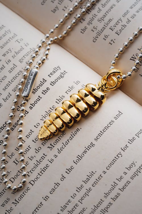 Necklace with Golden Dragon Tail on Book Page