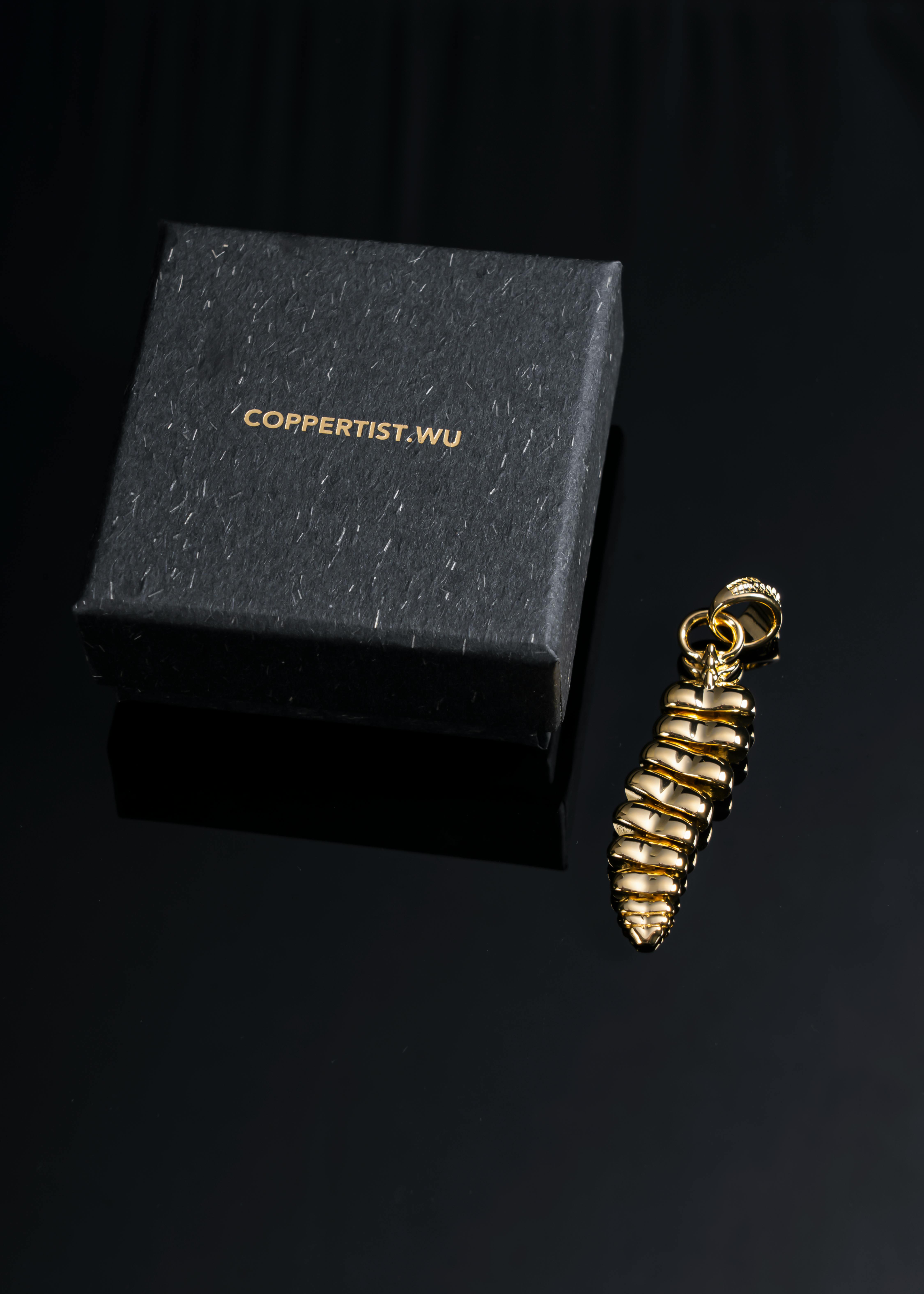 A sophisticated gold dragon tail pendant displayed next to a COPPERTIST.WU gift box.