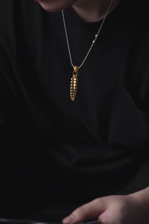 Free Rectangular gold pendant necklace on black clothing, stylish and modern. Stock Photo