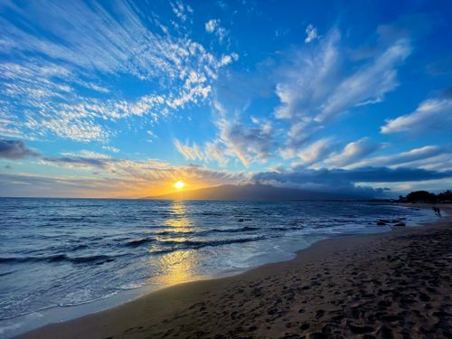Free Serene sunset at Kihei Beach, Hawaii with striking clouds and a scenic ocean view. Stock Photo