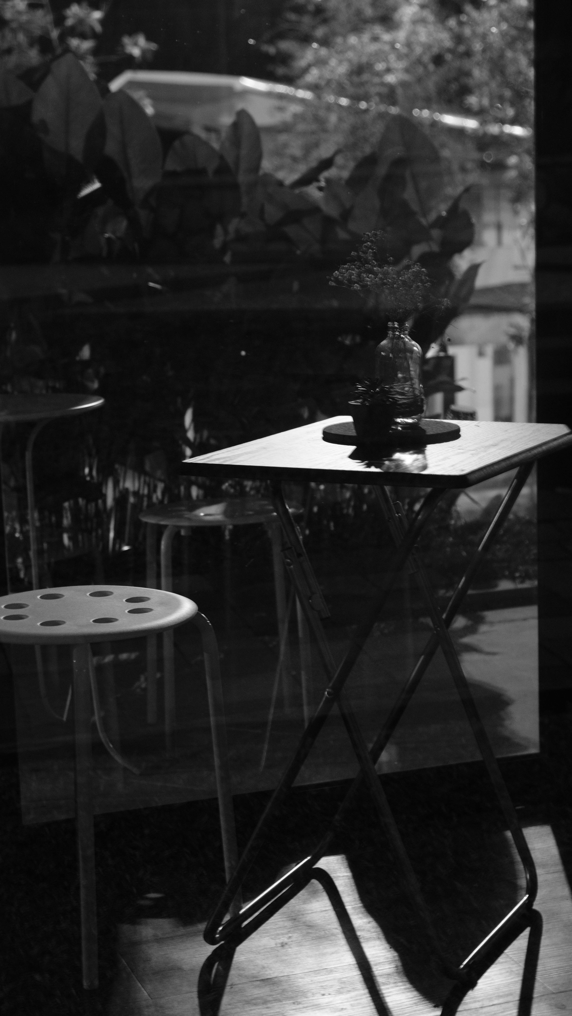 Free Monochrome image of a table and chair reflecting urban setting. Stock Photo