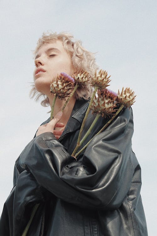 A Woman in Leather Jacket Holding Flowers