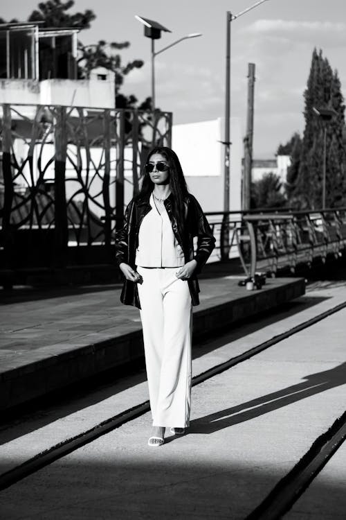 Model Posing in White Pants and Leather Jacket