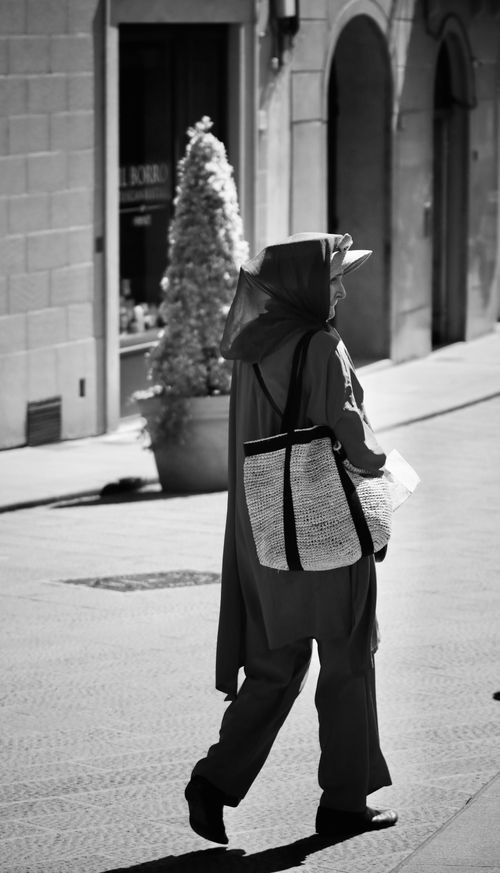 Free A woman in a hijab walks through Florence, capturing a timeless street style. Stock Photo