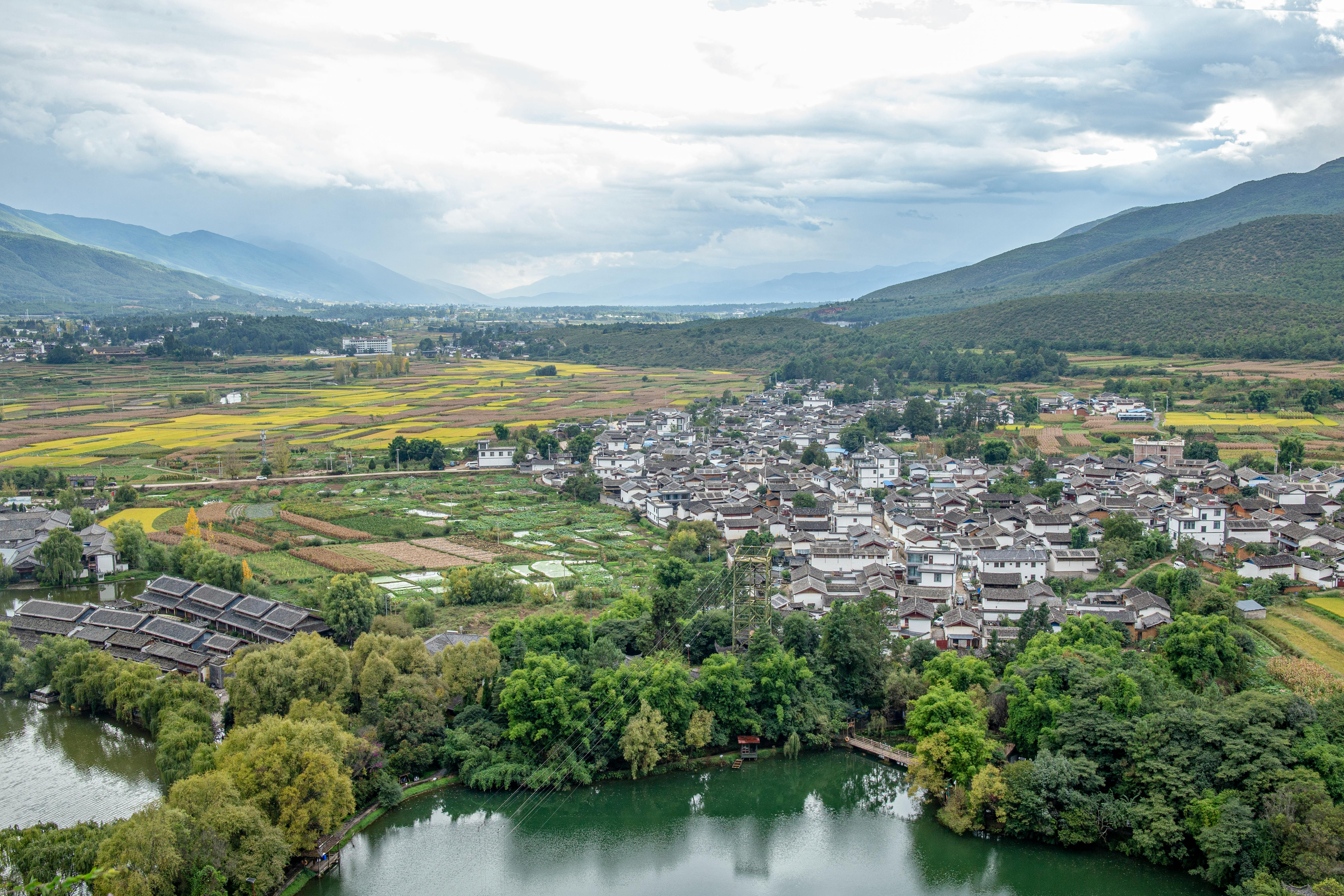 Breathtaking aerial view of a mountain town surrounded by lush fields and greenery.