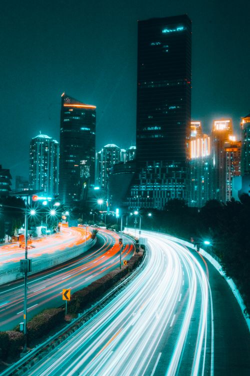Free Bright light trails on a highway in a vibrant city skyline at night, showcasing modern skyscrapers. Stock Photo
