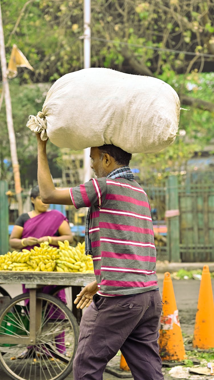 Man Carrying Heavy Bag On Head