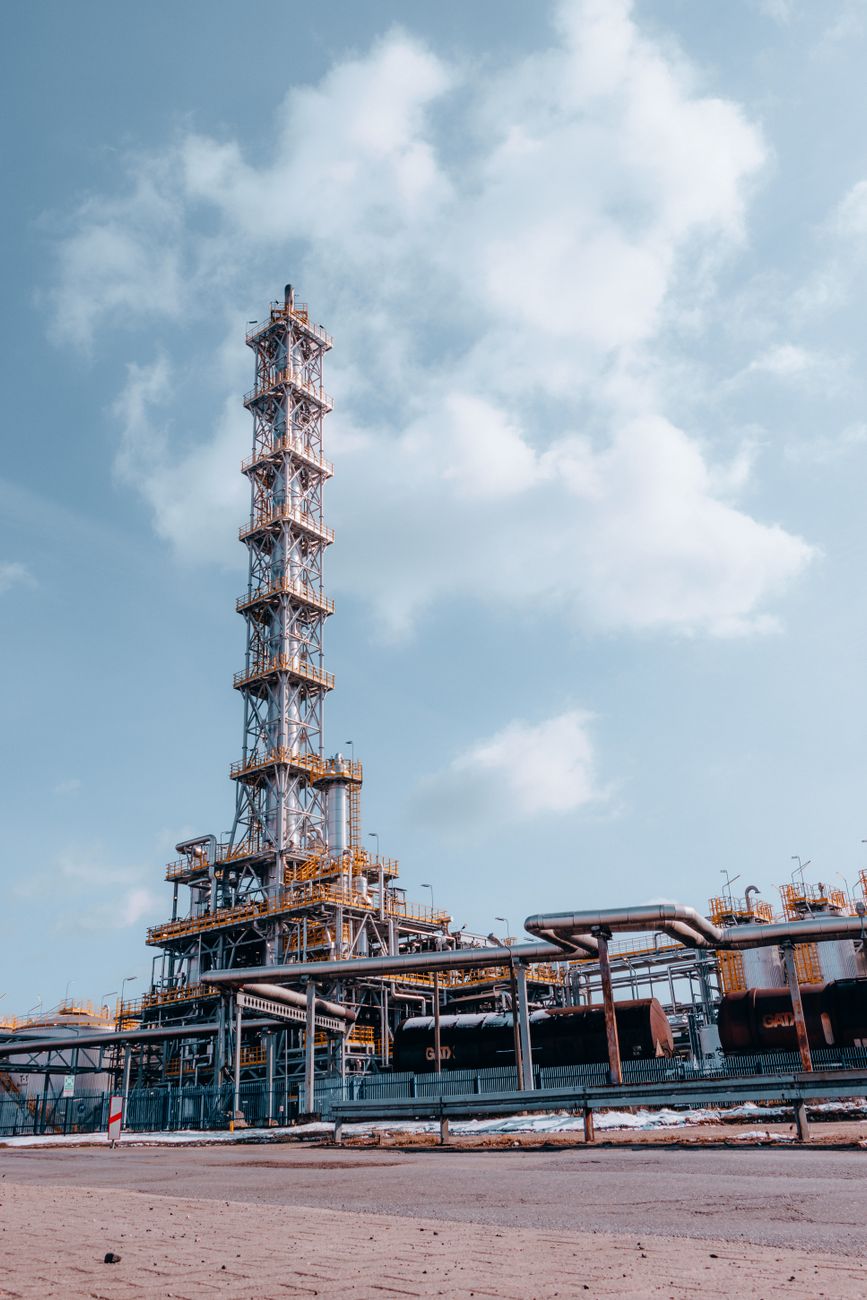 Oil refinery towers at a petrochemical plant producing Group III base oils critical for synthetic motor oil manufacturing