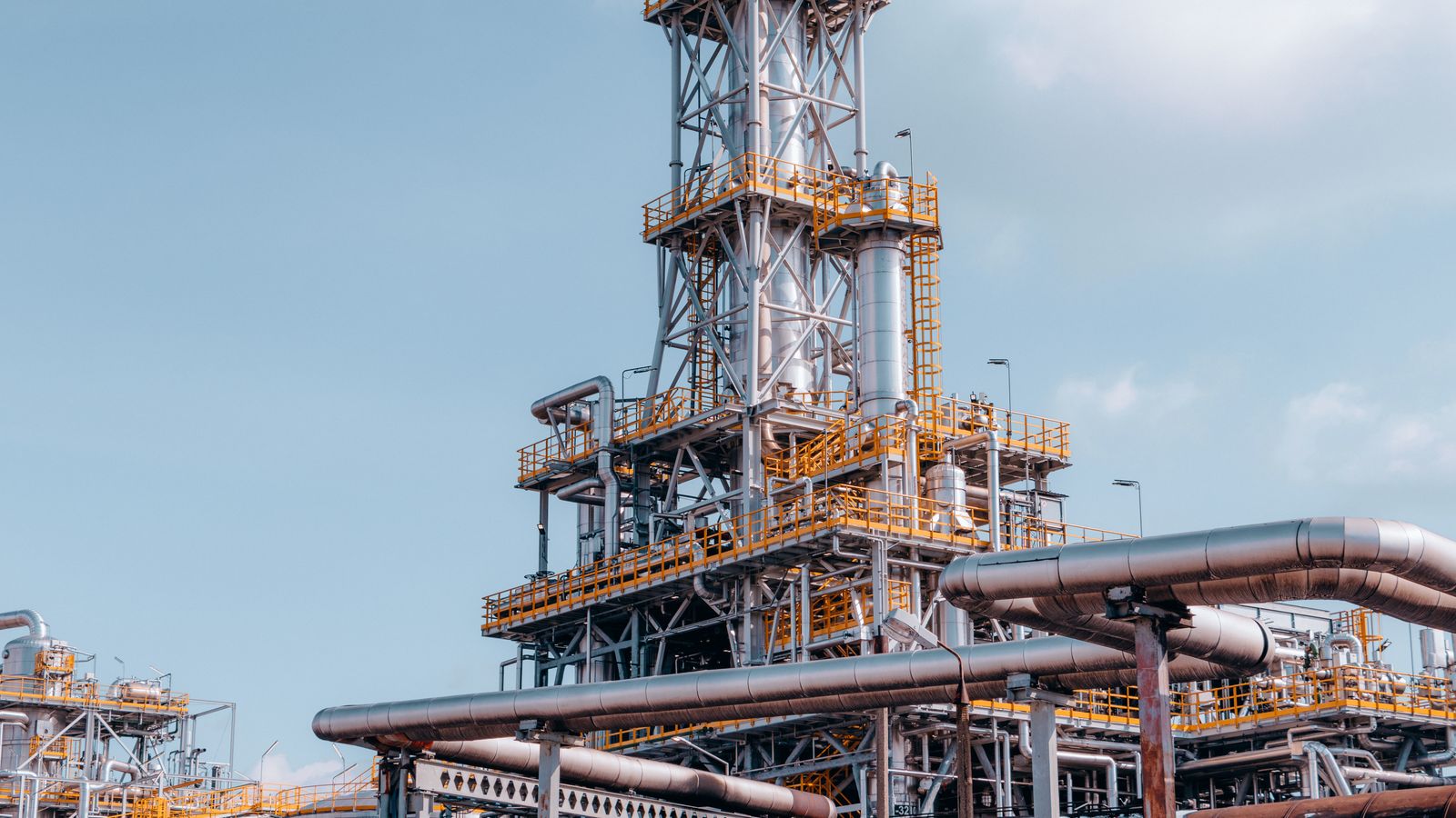 Modern petroleum refinery with processing towers and pipelines, representing oil and gas operations