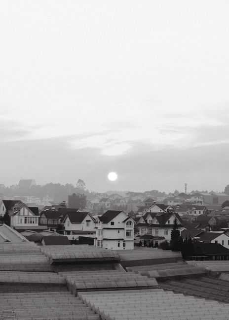 Captivating black and white townscape featuring rooftops and a serene sunrise.