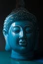 蓝色陶瓷佛头雕塑的特写视图，象征和平与灵性