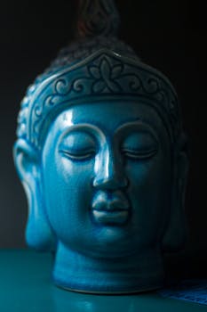 Close-up view of a blue ceramic Buddha head sculpture symbolizing peace and spirituality.