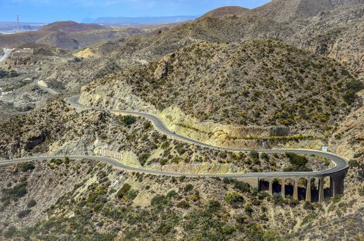 Scenic aerial view of a winding road through the arid hills of Carboneras, Spain.