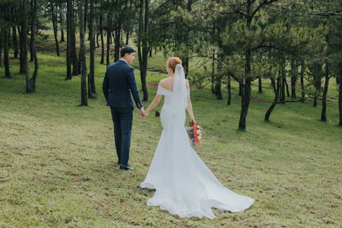 Newlyweds Walking and Holding Hands in Park