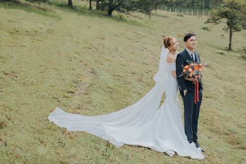 Newlyweds Posing with Flowers Bouquet