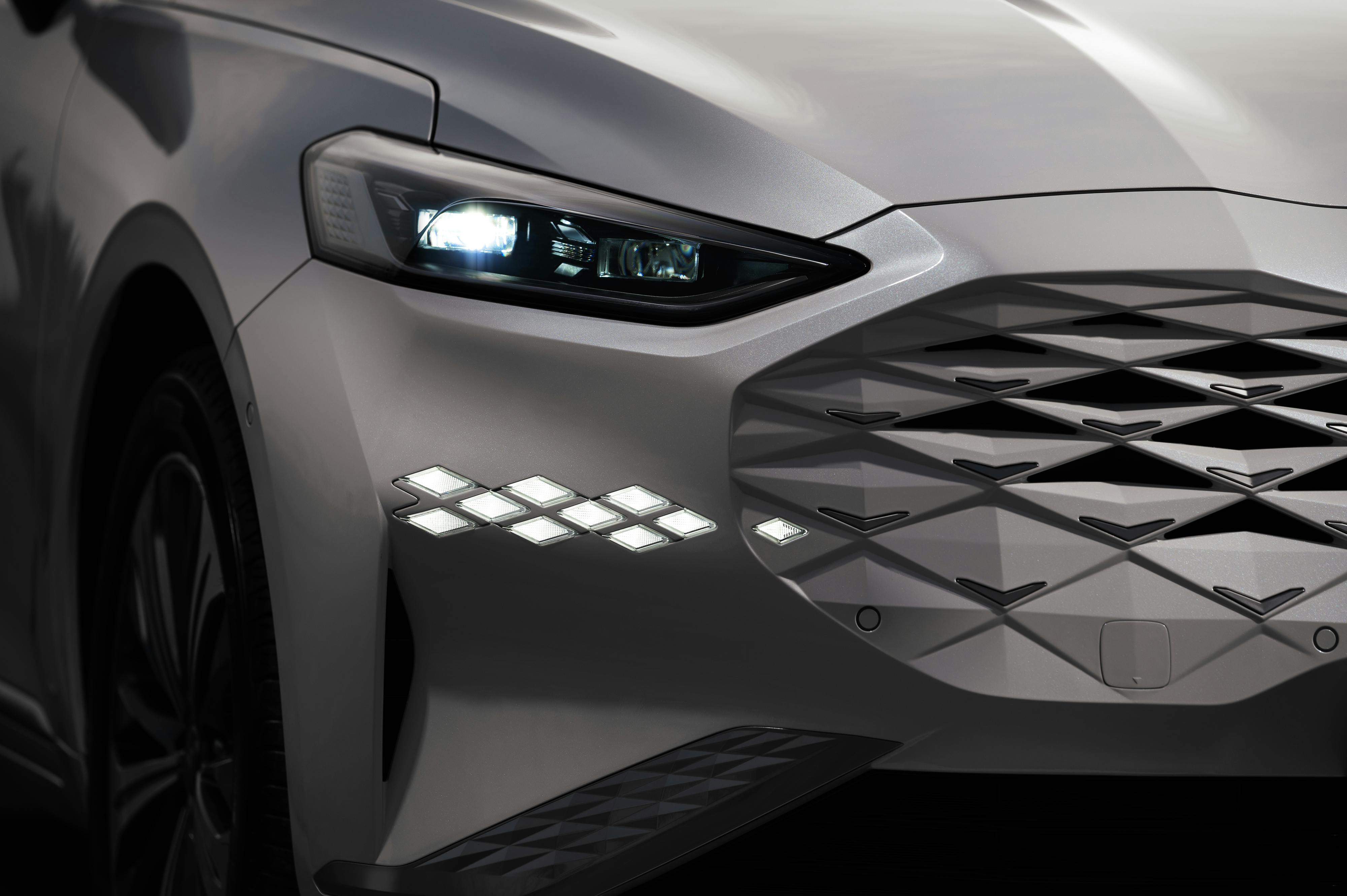 Close-up image of a modern car, showcasing a futuristic headlight and sleek design.