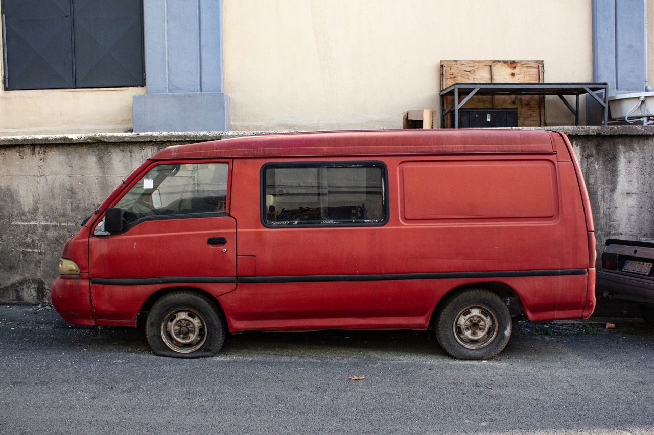 Roter Lieferwagen steht auf einem städtischen Parkplatz