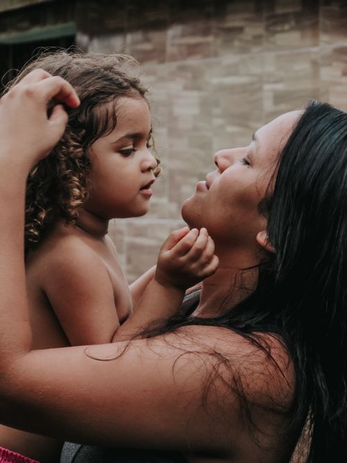 Free A warm, intimate portrayal of a mother and daughter sharing a tender embrace outdoors. Stock Photo