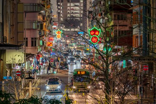 Free Vibrant city street illuminated by neon lights, buzzing with nighttime traffic and activity. Stock Photo