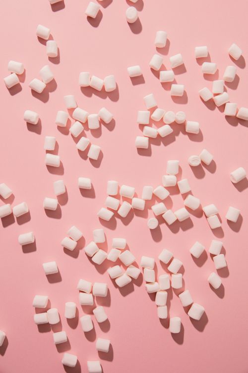 Free Scattered marshmallows on a pink background. Perfect for sweet and candy-themed designs. Stock Photo