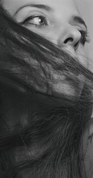Intriguing black and white portrait of a woman with long hair and expressive eyes.