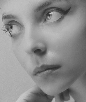 Close-up black and white portrait of a woman looking thoughtfully to the side, capturing elegance and emotion.