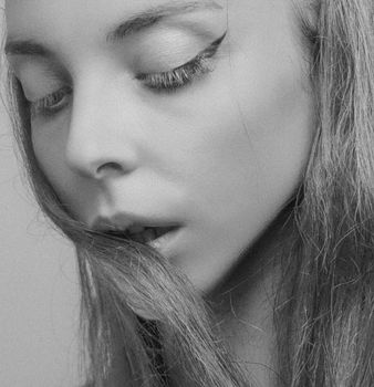 Elegant black and white portrait capturing a woman with eyes closed in thoughtful expression.