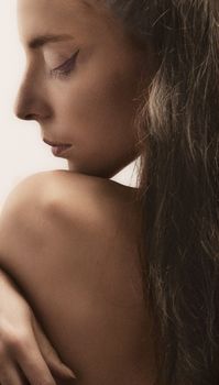 A serene portrait of a woman with long hair and eyes closed, conveying tranquility.