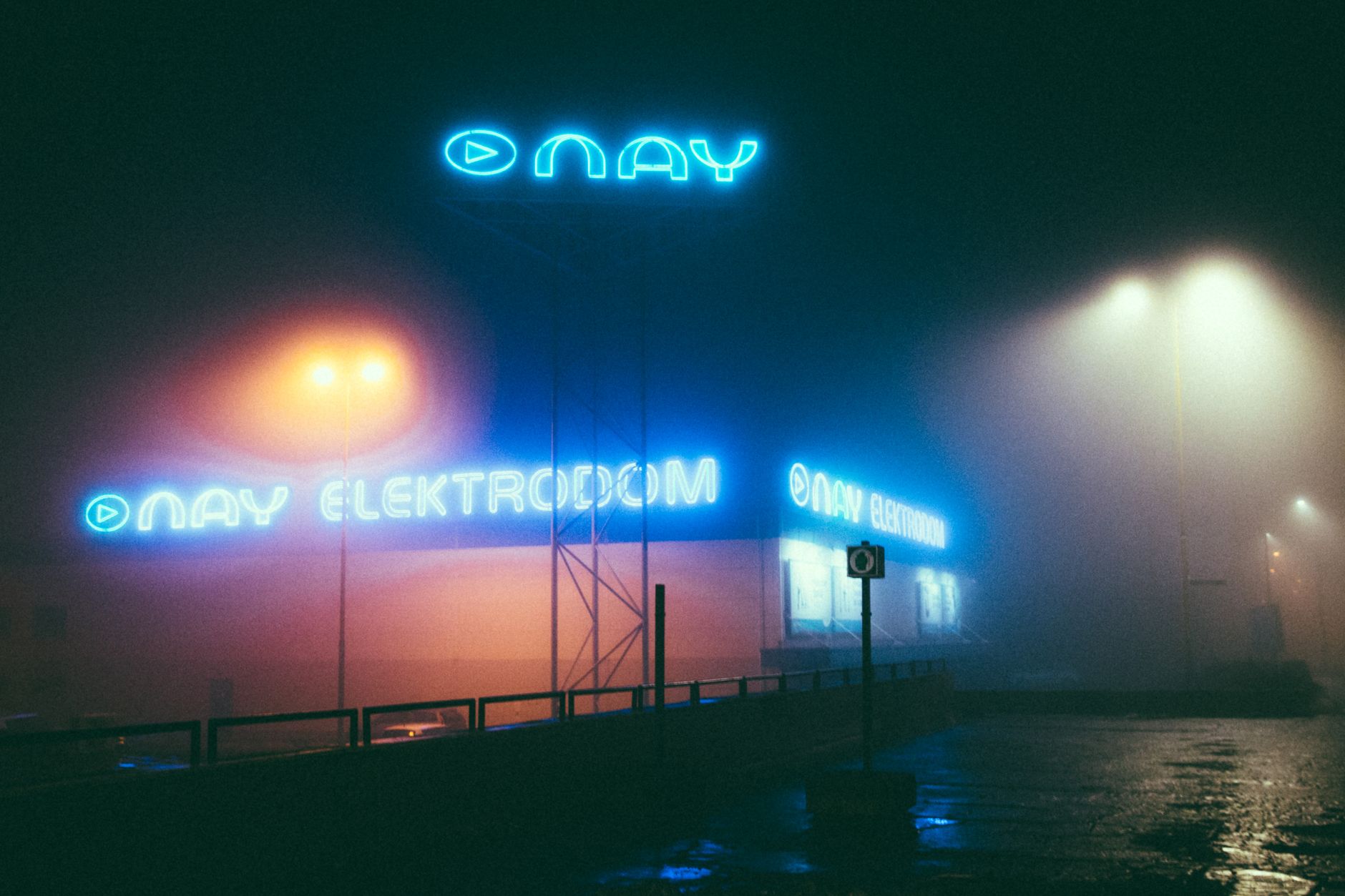 A person installing a large sign on a building facade.
