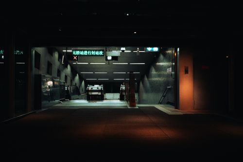 Free A dimly lit entrance to a subway station with escalators and signage at night. Stock Photo