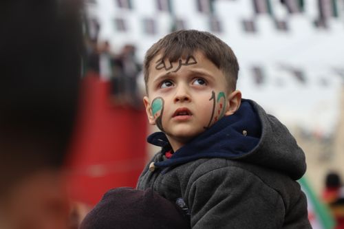 Free Young boy with face paint at a Syrian-themed patriotic gathering outdoors. Stock Photo