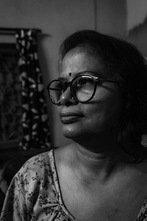 Free A thoughtful black and white portrait of a woman wearing glasses and a bindi, indoors. Stock Photo