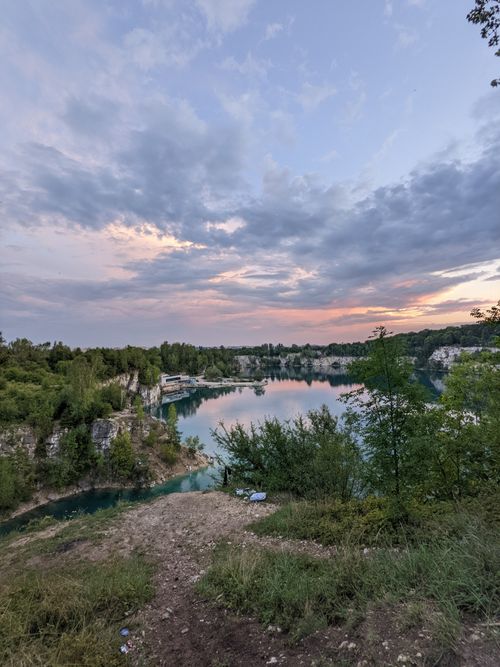 Free Tranquil twilight view of a quarry lake reflecting the colorful sky. Perfect for travel and nature enthusiasts. Stock Photo