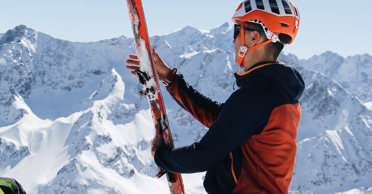 A man with skis on his back sitting on a mountain · Free Stock Photo