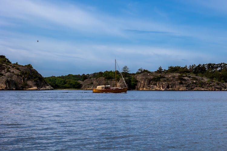 Boat On A Lake Surrounded By Hills And Trees 