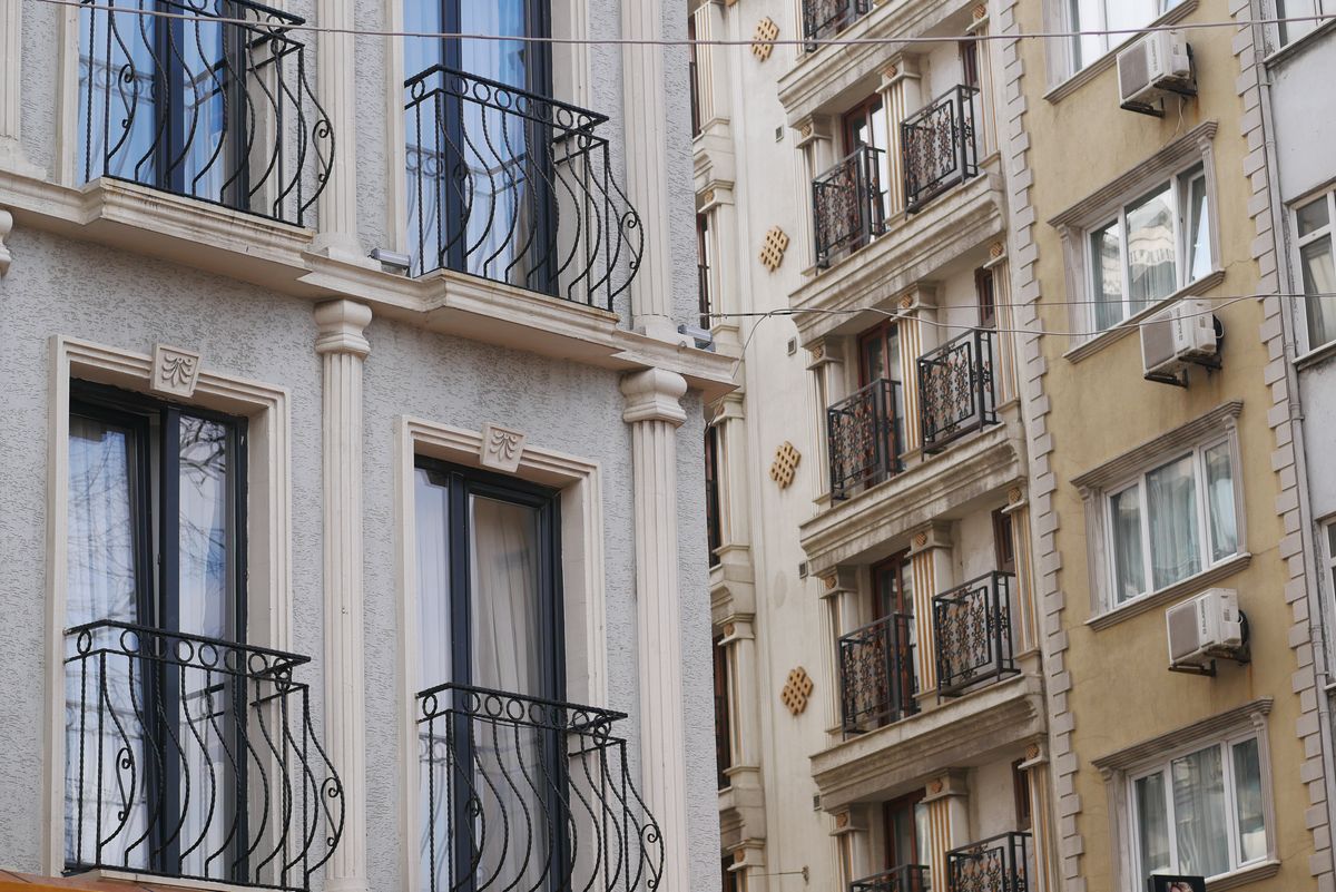 Fachada de edificios de viviendas con balcones de hierro y unidades exteriores de climatización instaladas en los huecos