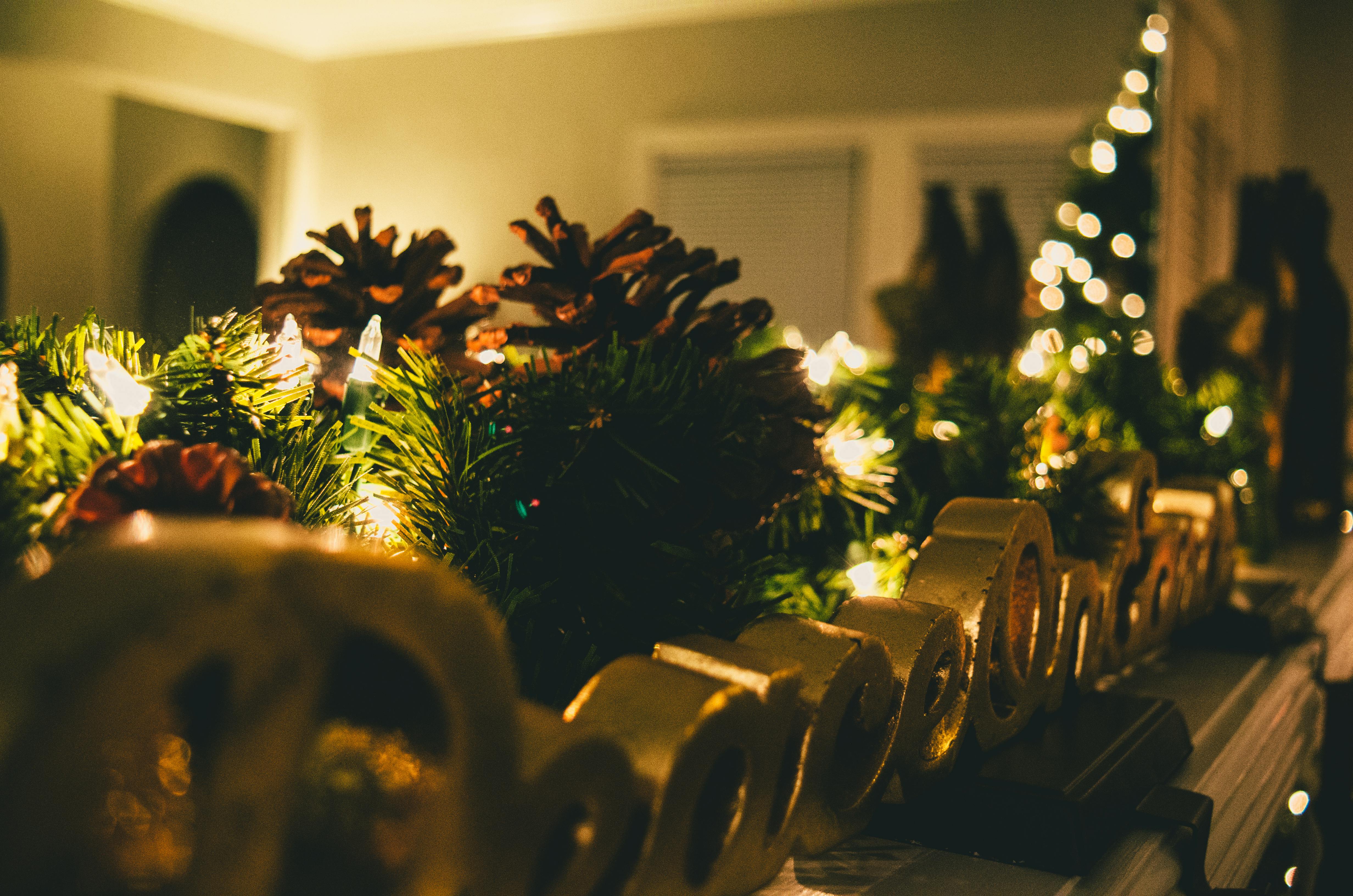 Warm and cozy Christmas mantel decorated with pine cones, lights, and festive ornaments.