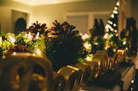 温暖的壁炉架上装饰着松果、灯光和节日饰品，舒适又温馨