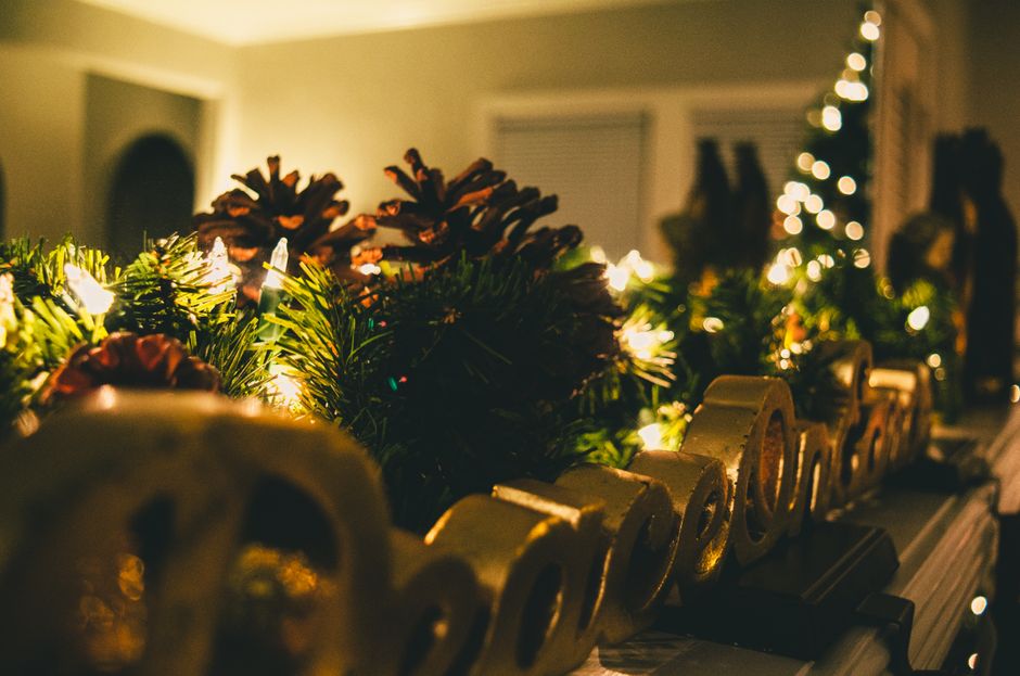 Warm and cozy Christmas mantel decorated with pine cones, lights, and festive ornaments.