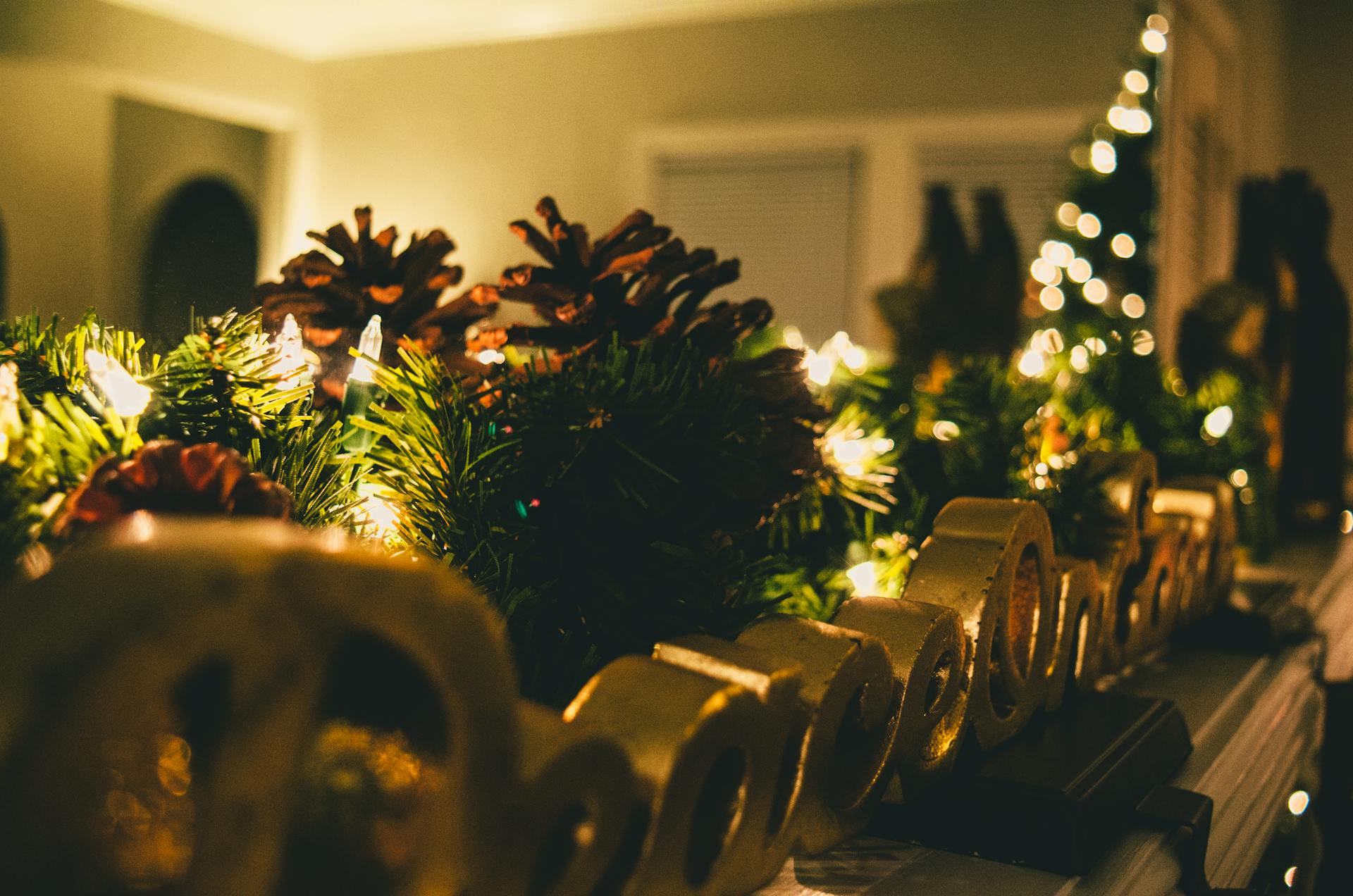 Warm and cozy Christmas mantel decorated with pine cones, lights, and festive ornaments.