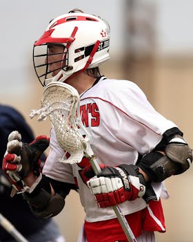 在比赛中，男长曲棍球运动员穿着制服和头盔，专注于比赛