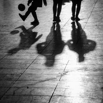 Black and white photo of silhouettes playing soccer