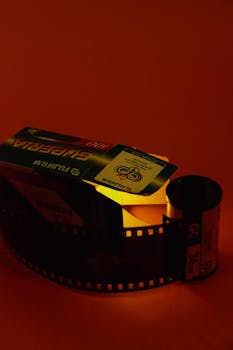 A vibrant image of Fujifilm Superia roll film lit with warm red studio lighting.