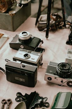A variety of classic analogue cameras displayed on a table, showcasing retro technology.