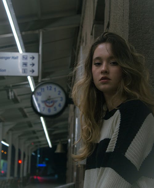 A woman standing in front of a clock