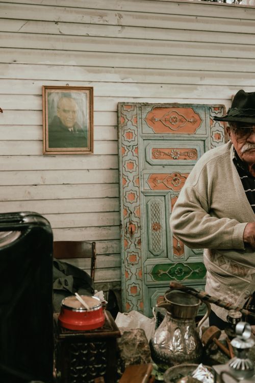 Free Charming indoor flea market scene featuring an elderly vendor with antiques and retro decor. Stock Photo